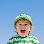 Child wearing a green cap and striped shirt against a clear blue sky