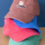 Stack of colorful caps with 'Tiny Rebel' logo on a blue background