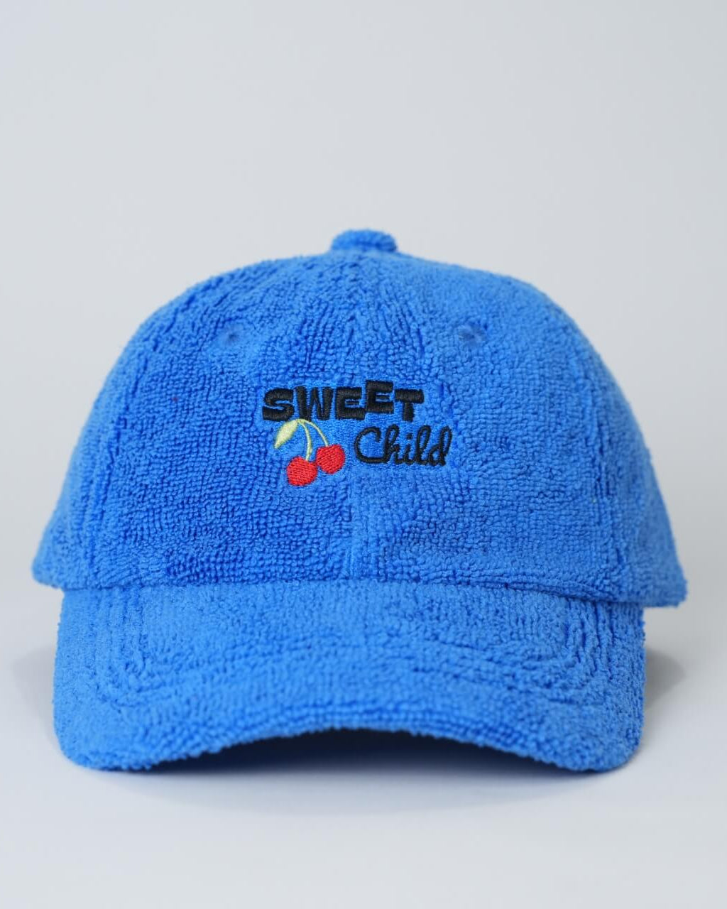 Blue cap with 'Sweet Child' text and cherries on a light gray background