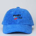 Blue cap with 'Sweet Child' text and cherries on a light gray background