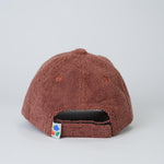 Brown textured cap with a colorful tag on a light gray background