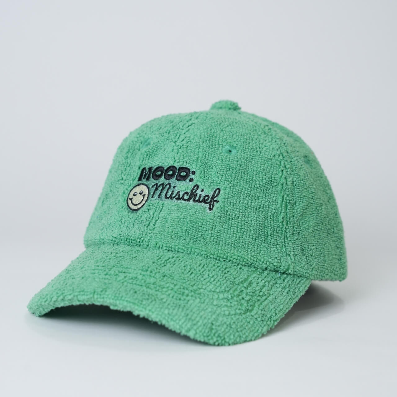 Green cap with 'Mood: Mischief' text on a light gray background
