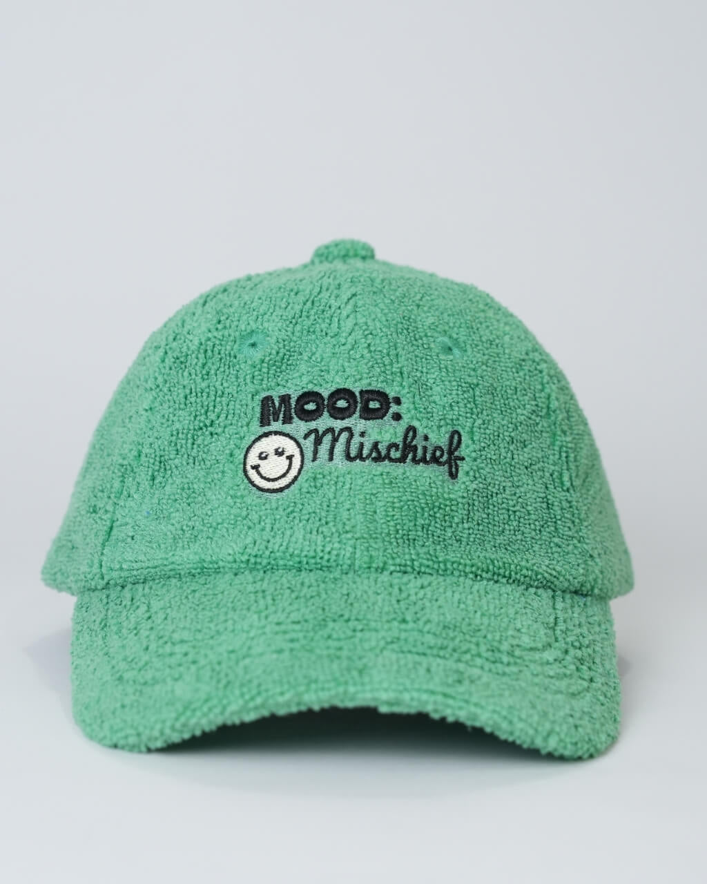 Green cap with 'Mood: Mischief' text and smiley face on a light gray background