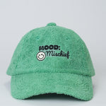 Green cap with 'Mood: Mischief' text and smiley face on a light gray background