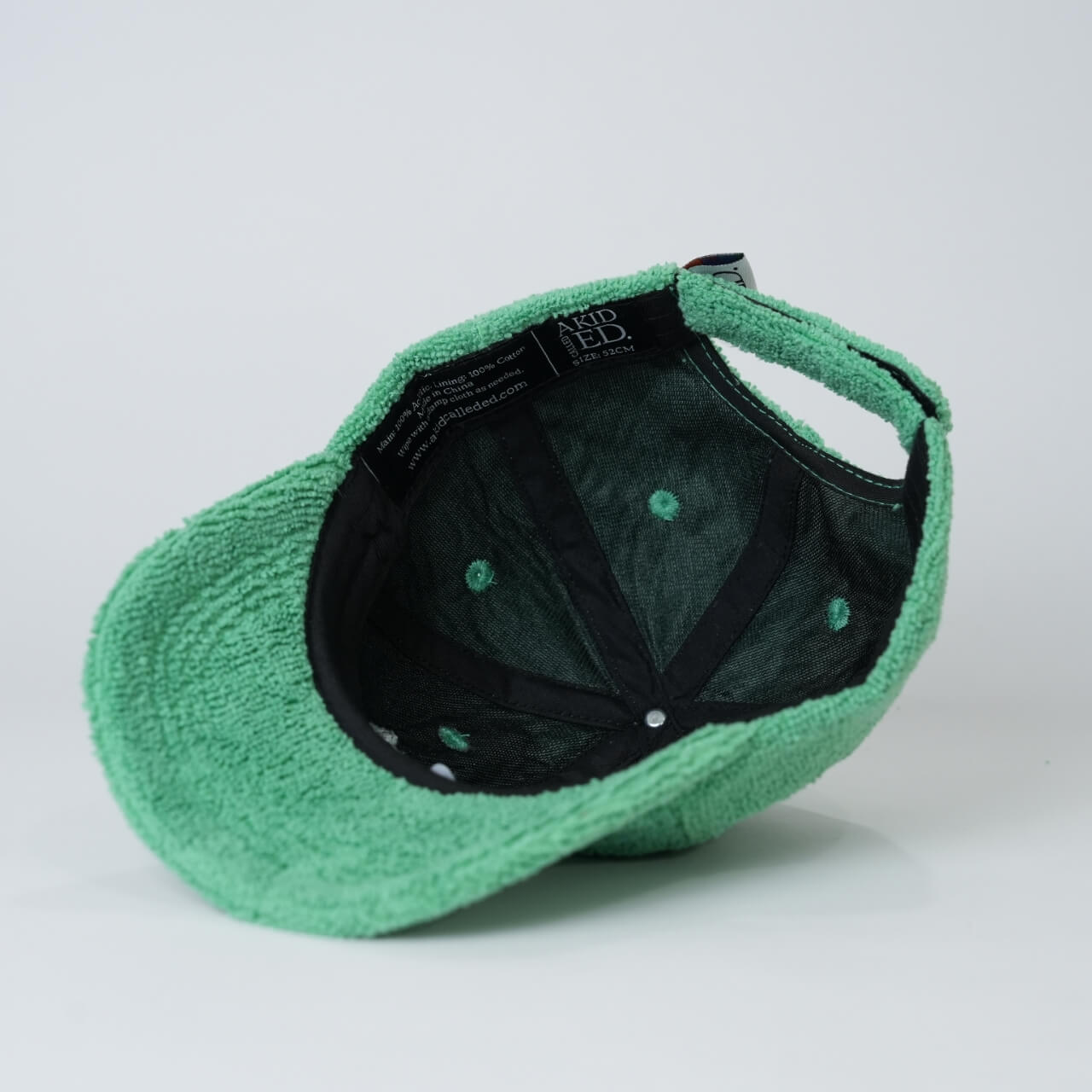 Green cap with black interior on a light gray background