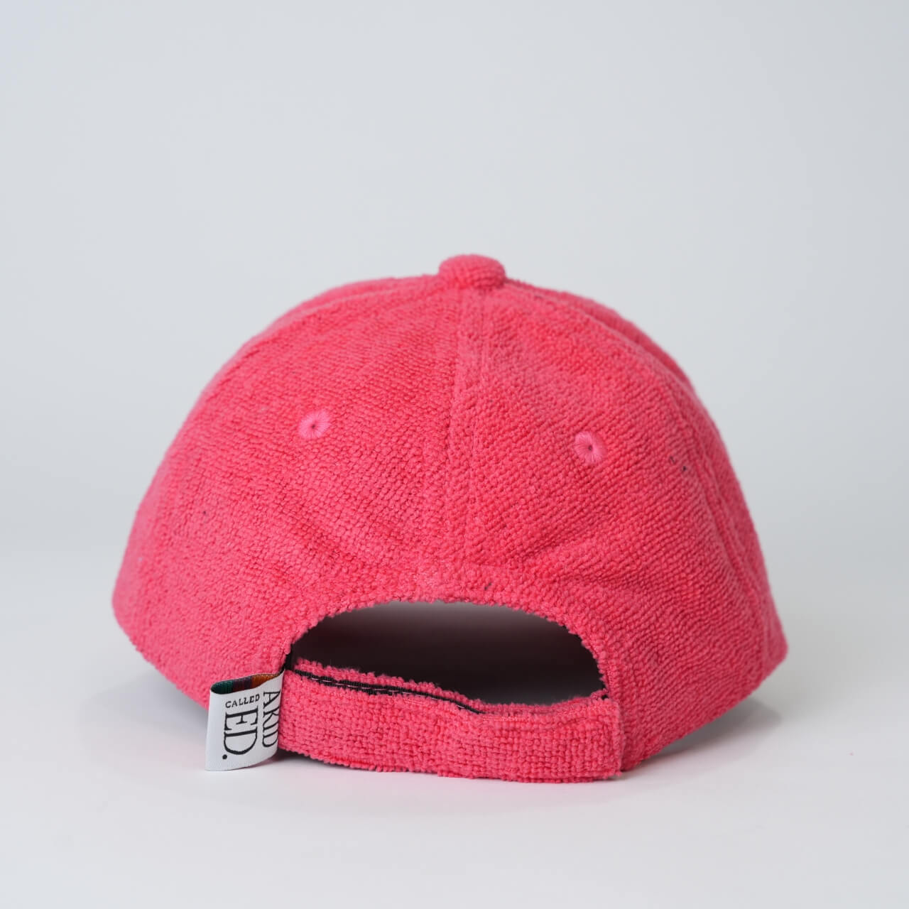 Red textured baseball cap on a light gray background