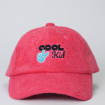 Red cap with 'Cool Kid' text and peace sign on a light gray background