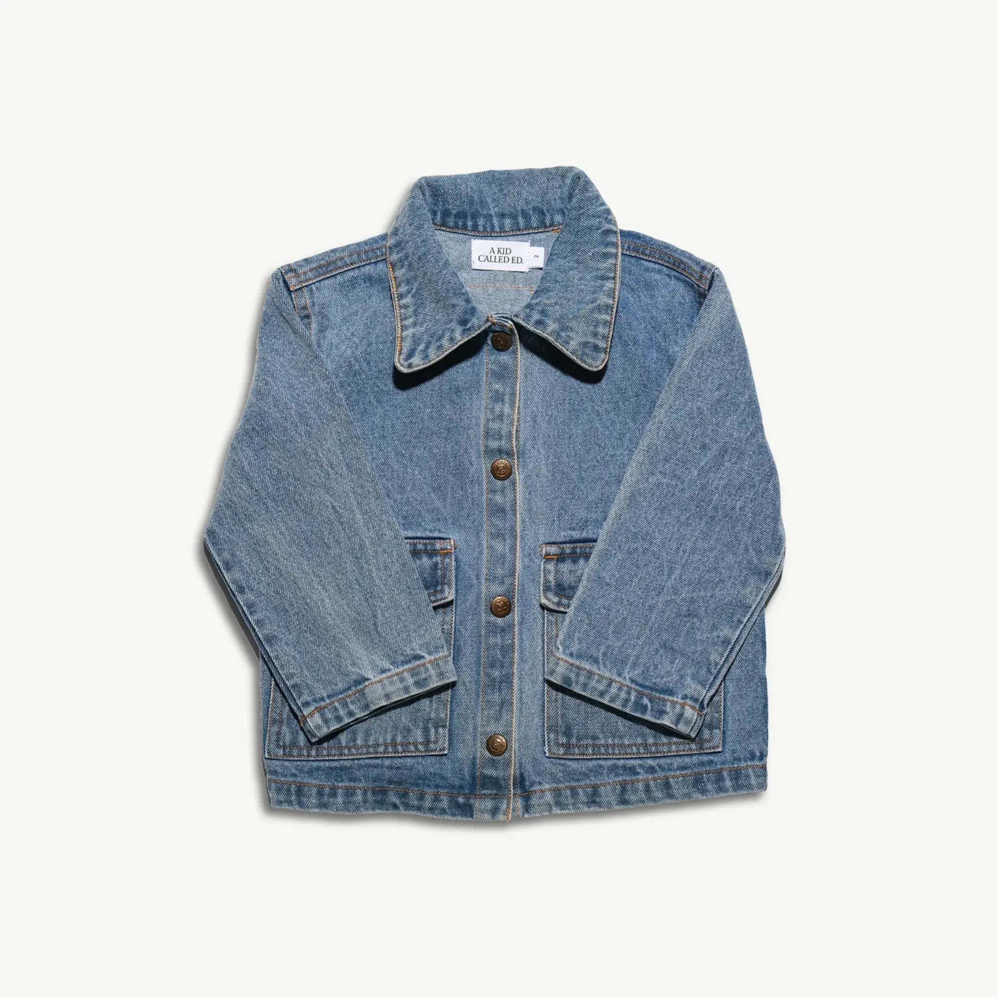 Kids organic cotton denim jacket shown from the front with the sleeves angled