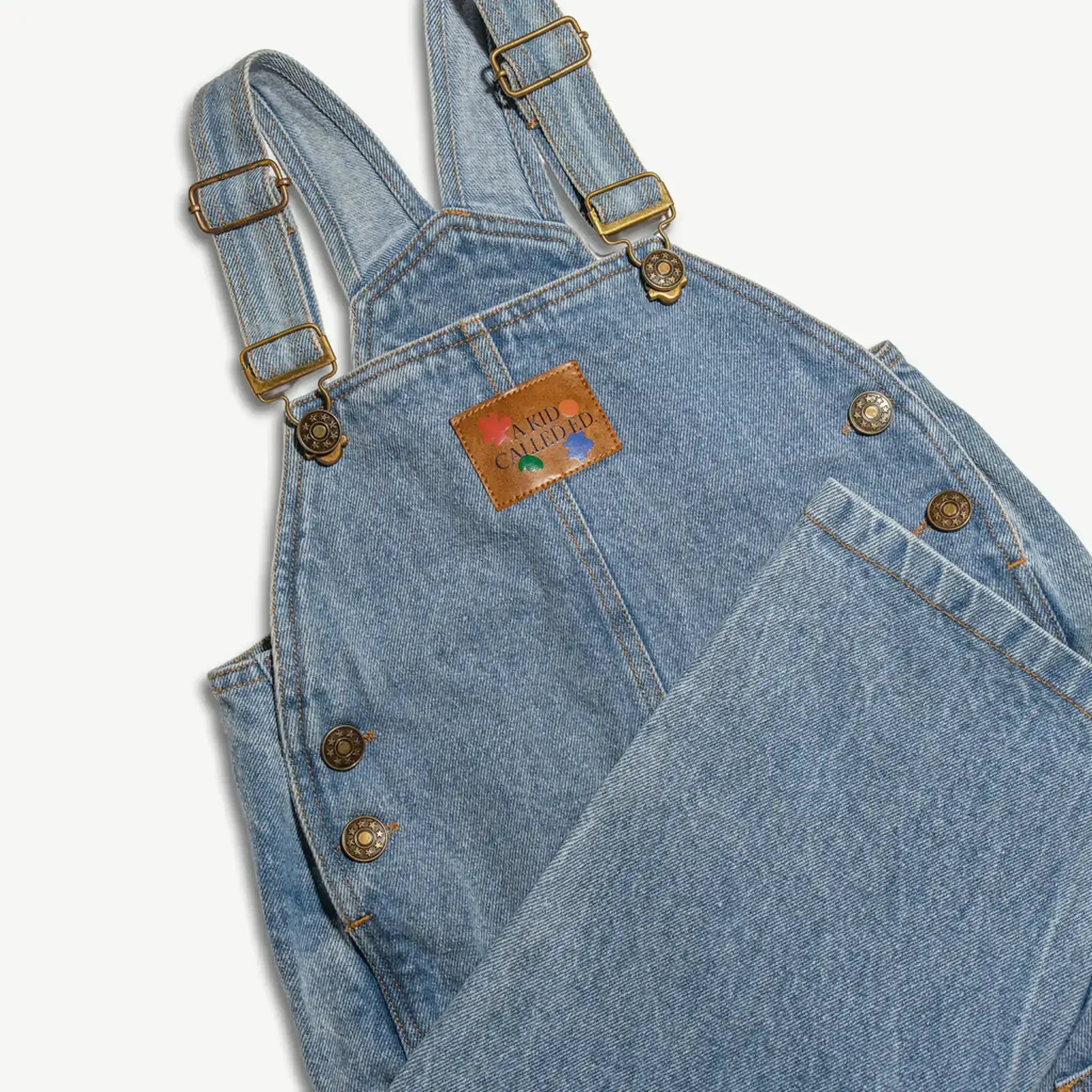 Kids organic cotton denim overalls styled with one leg folded