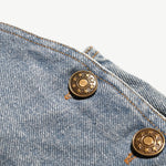 Close-up of the antique brass side buttons on the kids denim overalls