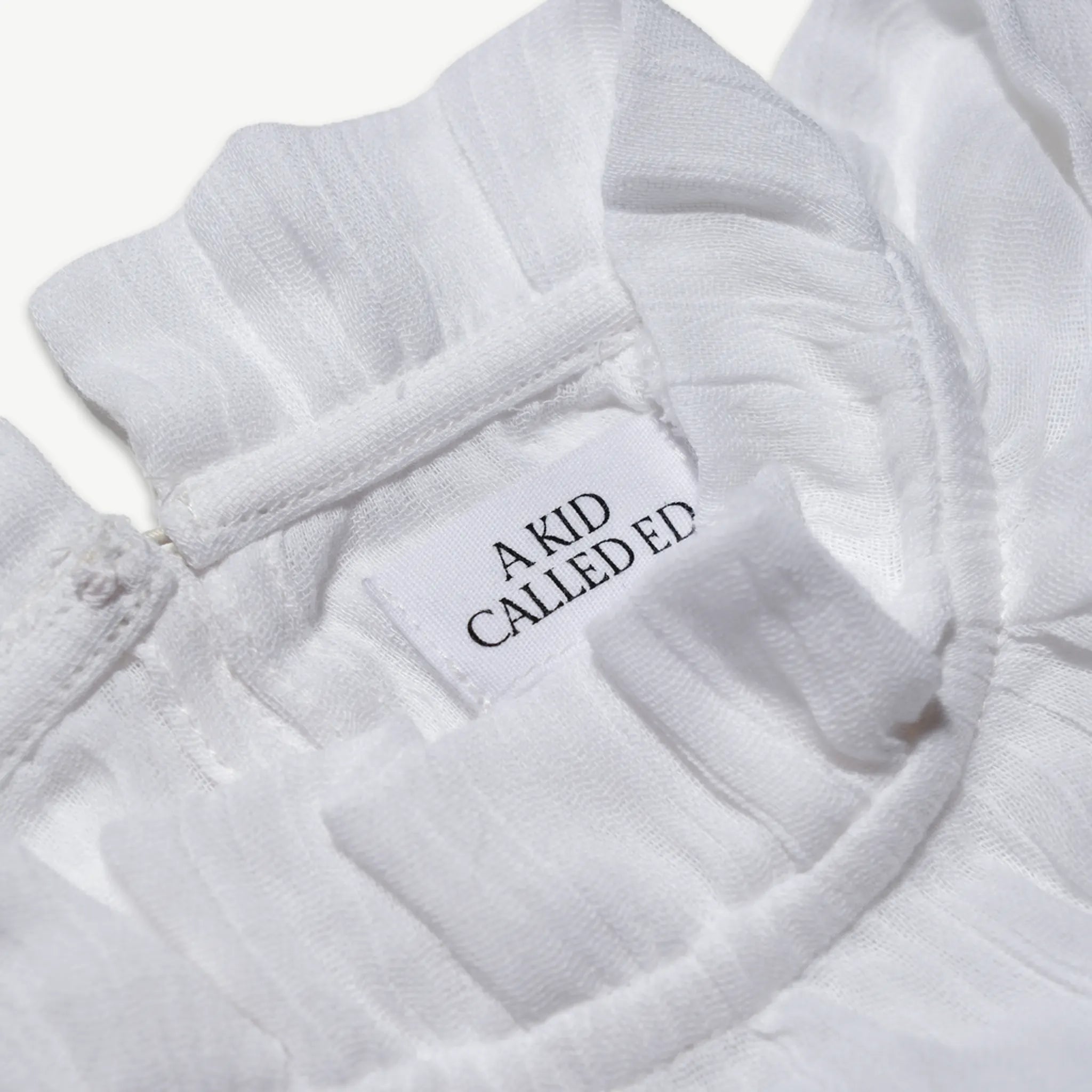Close-up of the A Kid Called Ed woven label inside the muslin blouse