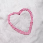 Close-up of the pink frilled heart pocket on the organic cotton muslin dress