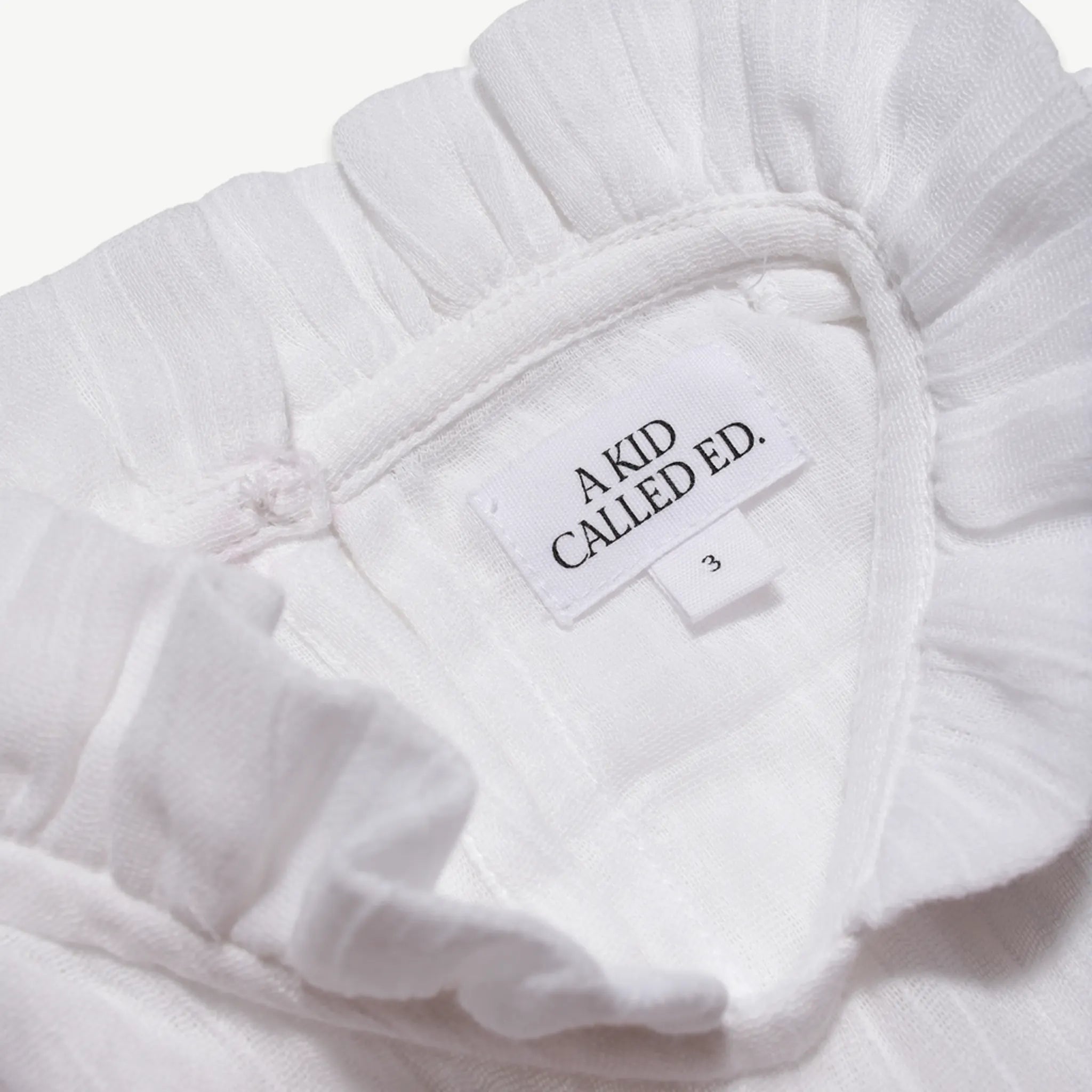 Close-up of the A Kid Called Ed woven label inside the muslin dress