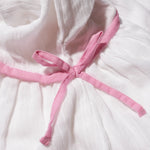Close-up of the pink bow tie at the neck of the kids muslin dress