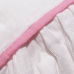 Close-up of the pink trim running through the organic cotton muslin dress